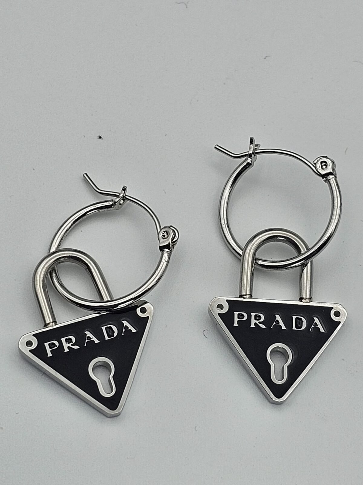Prada modeli siyah mineli gümüş kilit küpe