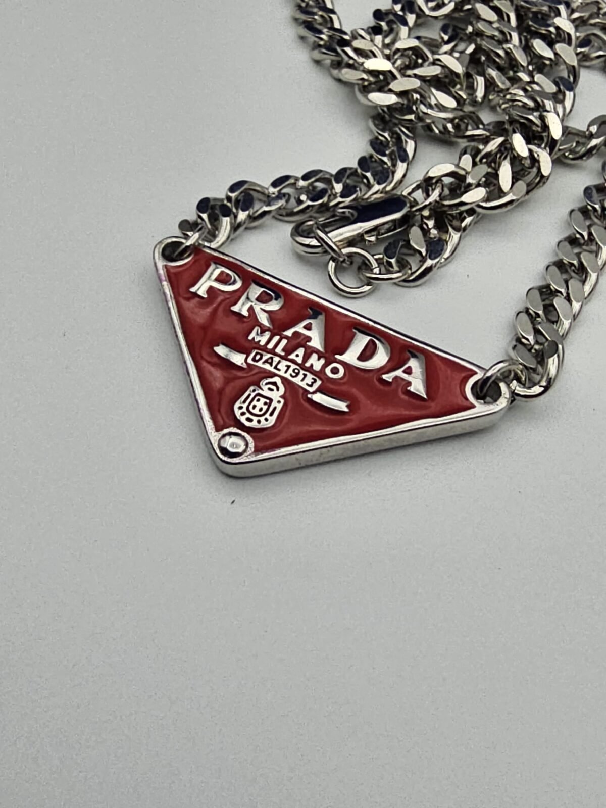 Prada modeli üçgen kırmızı mineli gümüş kolye